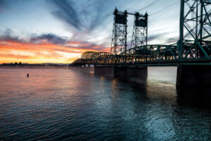 The wide, moving Columbia River showing the steel Interstate Bridge at Sunset with the sunset in the background.